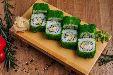 Sushi Rolls With Tobiko Green Caviar on wooden board