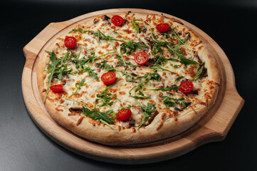Italian food. Classic pizza with large sides, mushrooms, cherry tomatoes, arugula, parmesan cheese on wooden board