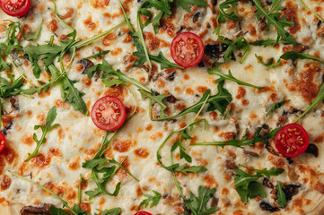 Italian food. Classic pizza with large sides, mushrooms, cherry tomatoes, arugula, parmesan cheese on wooden board