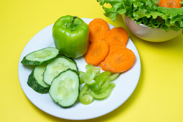 Delicious vegetable salad on a yellow background. Healthy diet food made from fresh vegetables. Vegetarian food
