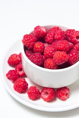 Raspberries in a cup on a white background. Red ripe raspberries close-up. Delicious berry