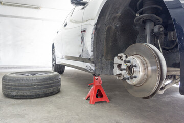 Car lifting it off the ground by Jack stands during car wheel maintenance on background,  Jack...
