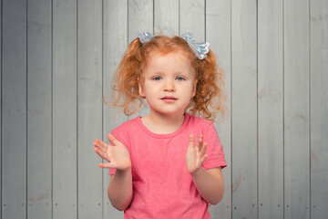 Portrait of cute redhead little girl in pink t shirt stare with curious and excited face, checking out something cool