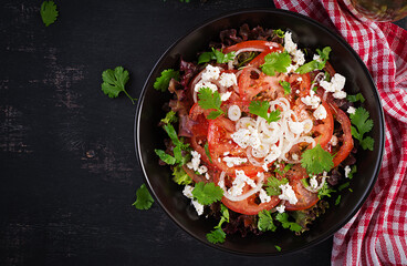 Vegetable salad with tomato, fresh lettuce, soft cheese and onion. Healthy diet food. Top view, above
