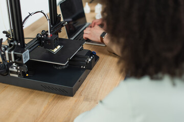 high angle view of young designers working with 3D printer and laptop in modern office