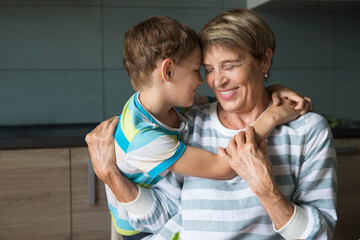grandmother and kid grandson hug and spend time together at home

