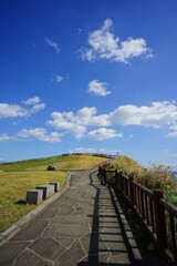 a beautiful seaside view with a cliff walkway, against charming clouds