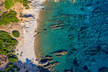 Aerial photo over granite rocky coastline Mediterranean crystal clear blue sea water. Aerial photo of ocean waves hitting rocky coastline of beautiful paradise dream tropical beach. Sardinia, Italy.
