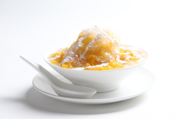 chilled fresh mango fruit sago ice snow kacang sweet dessert with coconut milk cream in white bowl