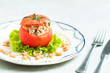 typical Belgian meal stuffed tomato with north sea shrimp on white and blue plate