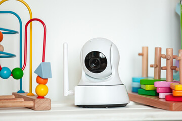 IP camera on the shelf with toys, serving as baby monitor