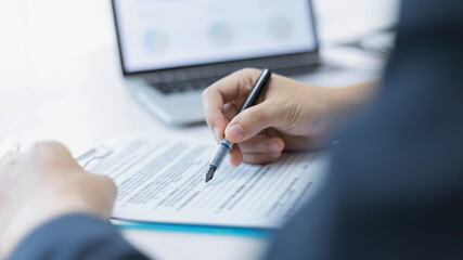 Business partners concept a young male entrepreneur signing a signature on the contract with a big company