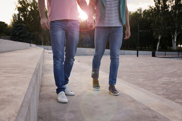 Gay couple walking outdoors on sunny day, closeup