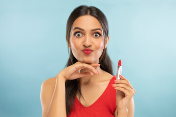 Portrait of beautiful young woman Holding lipstick