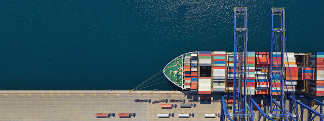 Aerial top down ultra wide photo of industrial container ship loading  - unloading colourful truck...