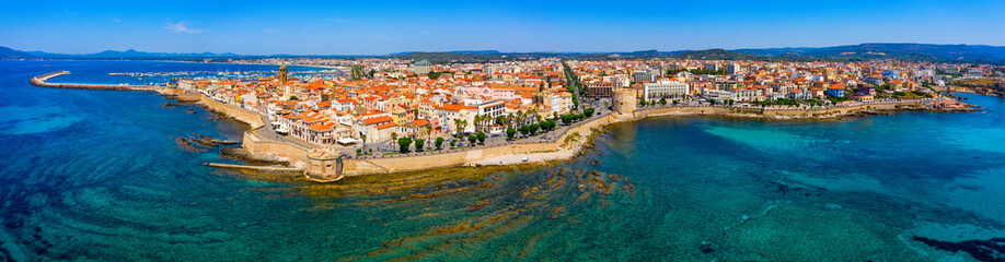 Aerial view over Alghero old town, cityscape Alghero view on a beautiful day with harbor and open sea in view. Alghero, Italy. Panoramic aerial view of Alghero, Sardinia, Italy. - obrazy, fototapety, plakaty