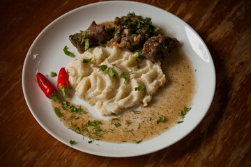 Cooking at home, mashed potatoes and steak, top view, daylight side light