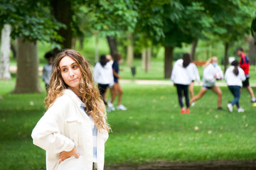 Fototapeta premium Portrait of an attractive young woman with people doing sports in the background.Healthy life concept.