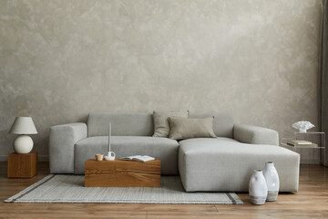 Creative composition of stylish modern spacious living room with grey sofa, wooden cubes, pillows,...