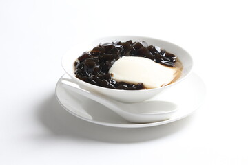 black herbal jelly with white soya milk pudding and sweet syrup in white bowl yuan yang traditional dessert menu