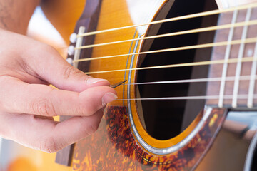 Obraz premium Close up to a guitar´s pick over the strings