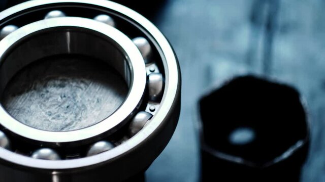 Pan shot of the large gearbox bearing on the shaft in a truck service station. Annual maintenance