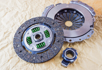 Car spare parts. Car clutch kit. Clutch disc, basket and clutch bearing. Car repair kit clutch manual gearbox on a background of craft paper.