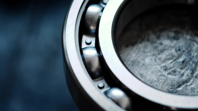 Close-up view of the large gearbox bearing on the shaft in a truck service station. Annual maintenance. blue background