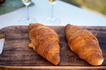 Breakfast with fresh baked croissants and  brut champagne sparkling wine in flute glasses served on outdoor bistro terrace in France