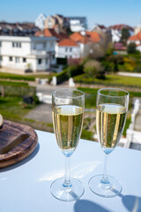 Drinking of brut champagne sparkling wine in flute glasses on outdoor bistro terrace in France