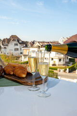 Drinking of brut champagne sparkling wine in flute glasses on outdoor bistro terrace in France
