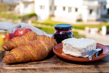 French breakfast with fresh baked croissants and cheeses from Normandy, camembert and neufchatel served outdoor with nice city view