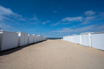 White beach huts on yellow sandy beach in small Belgian town Knokke-Heist, luxury vacation destination, summer holidays