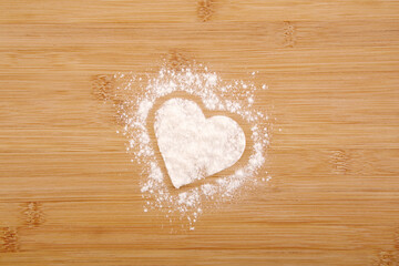 Obraz premium Heart made of flour on a wooden bamboo background
