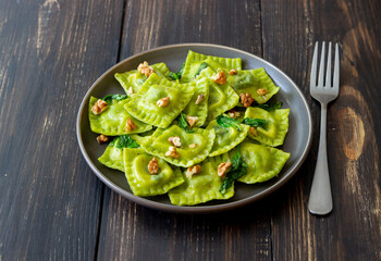 Green ravioli with ricotta cheese, spinach and nuts. Healthy eating. Vegetarian food. Italian cuisine.