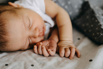 Closeup of a newborn baby sleeping, focus on fingers and nails.
