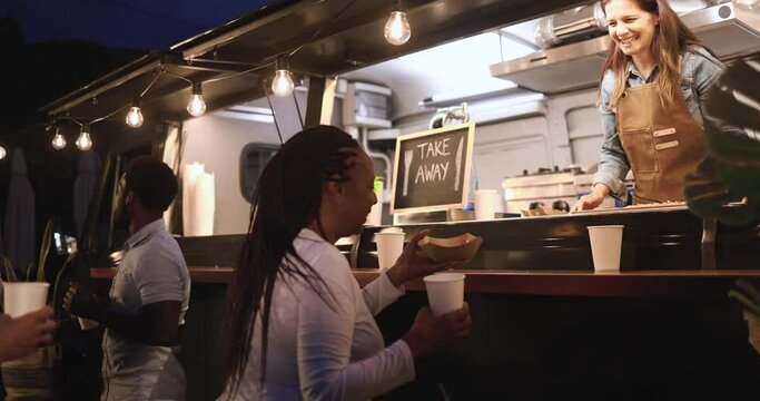 Caucasian woman chef working inside food truck preparing dinner food - Multiracial people ordering meal 
