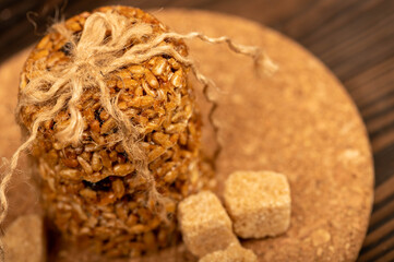 Homemade cookies with sunflower seeds and raisins tied with string and pieces of brown cane sugar on a wooden table. Close-up Selective focus.