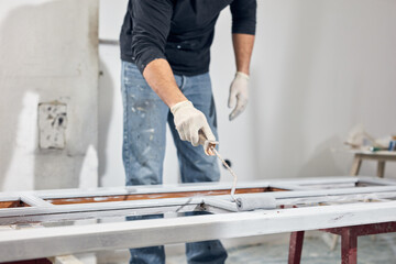 Young adult man painting on a DIY budget renovation of his new home apartment.