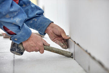 Ceramics tile man worker placing new tiles on the floor and wall.