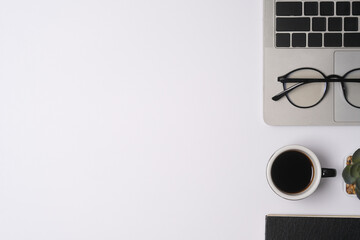 Top up view with office desk on white background that have laptop, eyeglasses and mug of coffee, workspace concept.