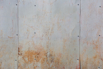 old sheets of iron on the wall of the house with remnants of paint and rust, background, texture