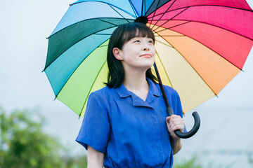 雨の中、カラフルな傘を指す女性