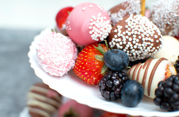 Variety of chocolate strawberries group of strawberries in chocolate on white plate and gray background, a dessert for Valentine's Day, a romantic, food gift.