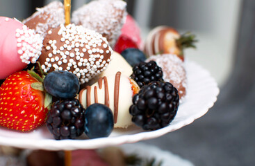 Variety of chocolate strawberries group of strawberries in chocolate on white plate and gray background, a dessert for Valentine's Day, a romantic, food gift.