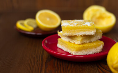 side view of juicy yellow lemon cakes on wooden background, stack of citrus cookies with lemon filling lying one on top of another, copy space