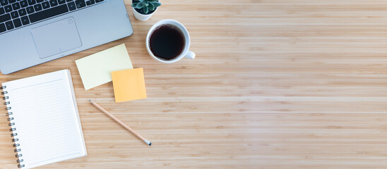 flat lay composition with notebook, pen, coffee, plant, laptop on wood background. top view