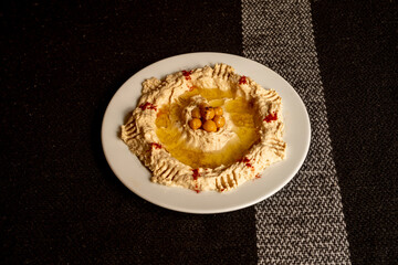 Traditional chickpea hummus with whole chickpeas cooked in the middle, plenty of olive oil and paprika powder