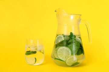 still life with lemon and lime, a jug of water, lime and melissa, glass with lime