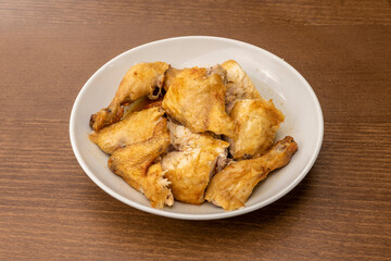 White bowl with chopped roast chicken and its juice served in a food delivery restaurant
